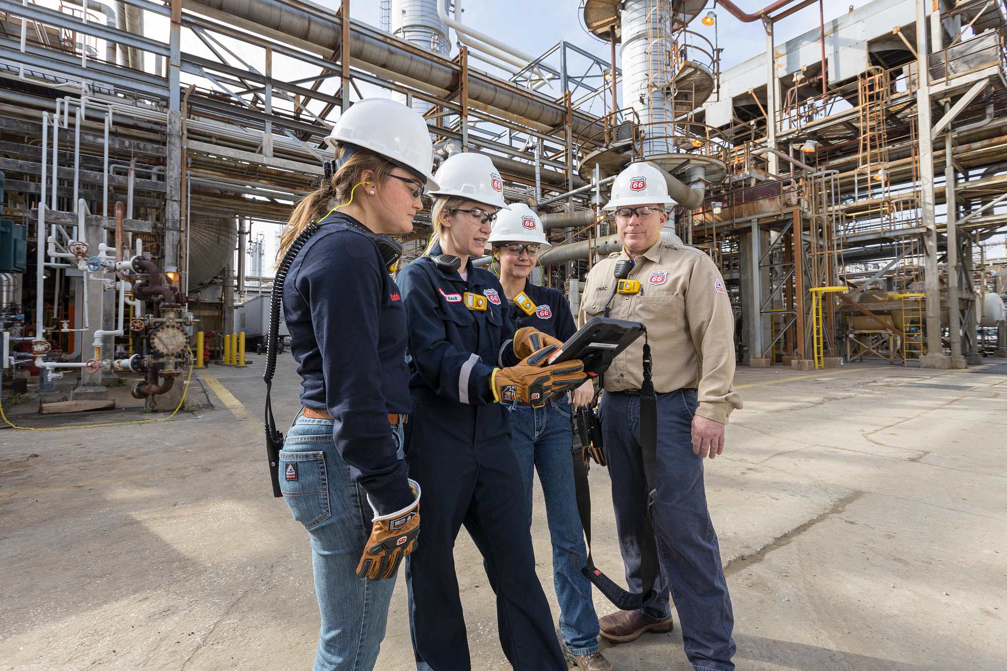 employees at Lake Charles Refinery in Louisiana, holding digital tools